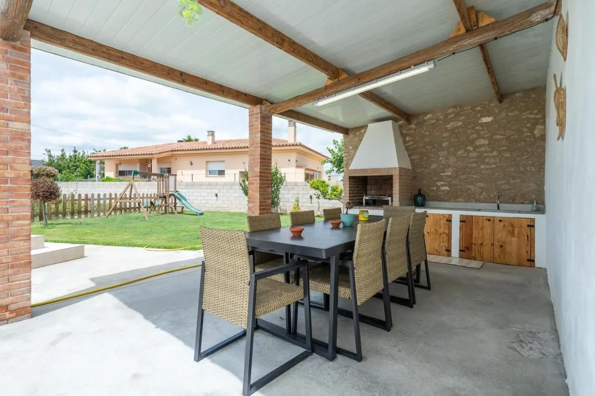 Terraza cubierta con mesa de comedor exterior