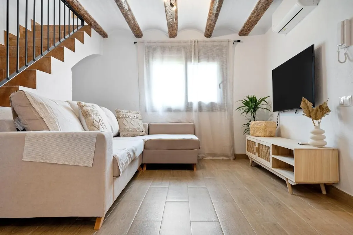 Salón con sofá chaise longue y TV en L’Hortet
